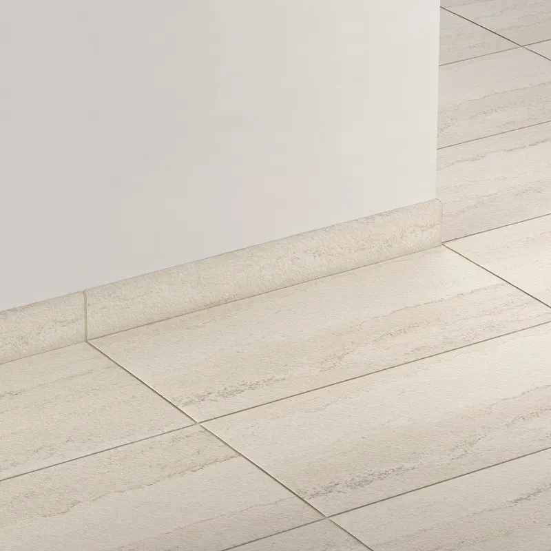 Elongated subway-style trim in grayish beige with a subtly textured surface, creating a smooth transition between wall and floor.