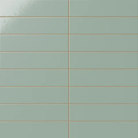 Glossy subway tile in a pale sage green tone with a flat rectangular design, soft reflective glaze, muted green coloring, and warm linear grout contrast.