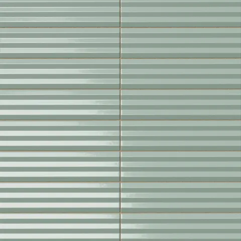 Ridged rectangular tile in a pale sage green tone with a glossy finish, subtle glaze variation, horizontal channeling, and a softly luminous surface.