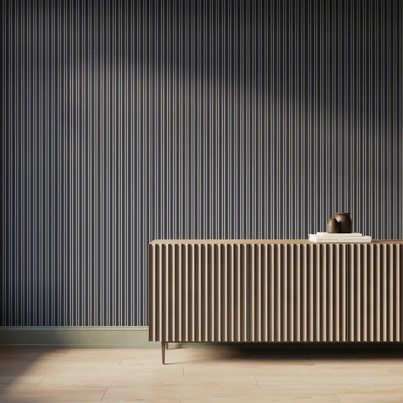 Modern interior featuring black vertical striped wallpaper, a fluted wood console cabinet with slim metal legs, light wood flooring, and soft natural light casting subtle shadows across the textured wall.