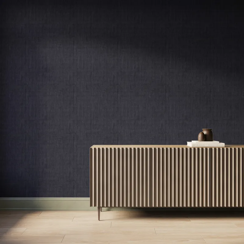 Modern interior with charcoal textured wallpaper, fluted wood sideboard, ceramic vase and books, styled in a calm minimalist setting.