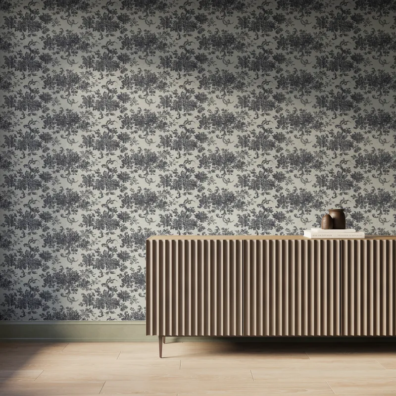 Interior scene featuring Brocade Wallpaper in Black II with a black damask floral motif over a matte off-white background, styled with a fluted wood console cabinet, decorative books and vases, and light wood flooring under soft natural light.