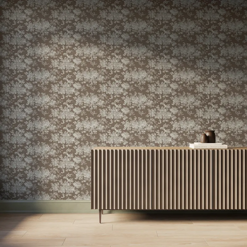 Interior scene featuring Brocade Wallpaper in Taupe I with a white damask floral motif over a grayish brown background, styled with a fluted wood console cabinet, decorative books and vases, and light wood flooring under soft natural light.
