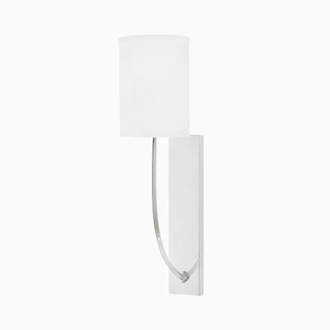 Wall sconce with a white linen shade and curved arm on a sleek polished nickel backplate, offering a crisp, modern elegance.