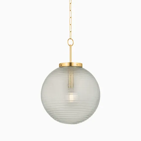 Round glass pendant light with subtle horizontal texture, suspended by an aged brass rod and chain from a matching ceiling mount.