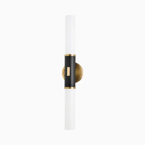 Gallagher wall sconce in aged antique distressed bronze with fluted black center and dual white glass tubes, balancing bold contrast with sleek symmetry.