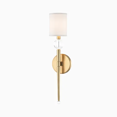 Elegant brass wall sconce with a one-piece tapered stem, clear crystal accents, and a white fabric drum shade for a timeless glow
