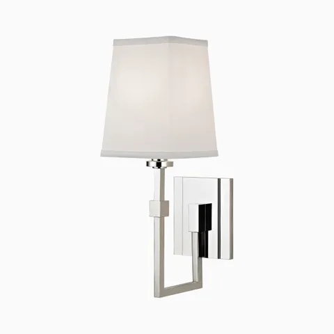 Polished nickel wall sconce with tapered white fabric shade and angular arm, offering a sleek modern lighting accent for walls.
