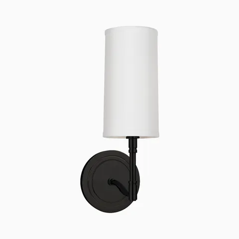 Old bronze wall sconce with round backplate, curved arm, and tall white fabric shade, offering a classic modern accent light.