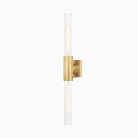 28" wall sconce with aged brass center mount, dual fluted glass column shades, and minimalist form for warm ambient lighting.