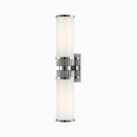 Wall sconce with twin opal glass cylinders and fluted polished nickel center band, bringing refined symmetry and luminous shine.