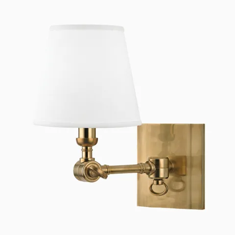 Aged brass wall sconce with rectangular backplate, swing arm design, and white tapered fabric shade for a timeless classic look.