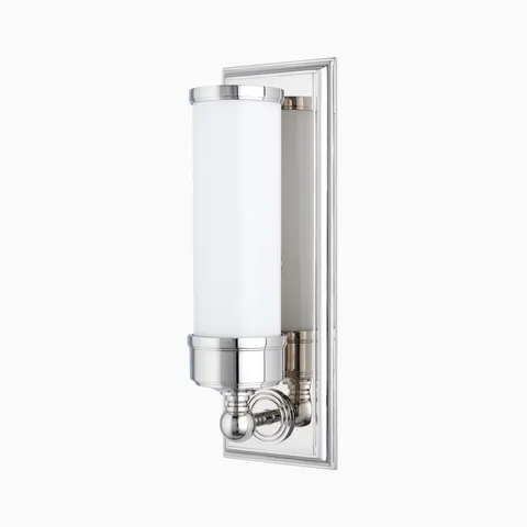 Polished nickel wall sconce with a cylindrical frosted glass shade and classic detailing, ideal for timeless bathroom elegance