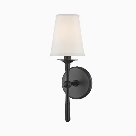 Matte black wall sconce with tapered white fabric shade and slender stem, offering a bold take on traditional elegance