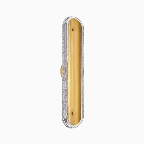 Bath and vanity light in vintage brass with an elongated oval design and textured clear glass border, mounted vertically.
