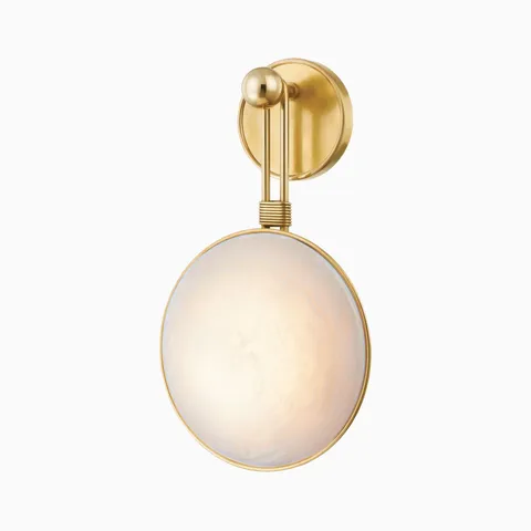 Vintage brass wall sconce with round alabaster diffuser and sculptural vertical arm, offering warm ambient lighting with refined detail.