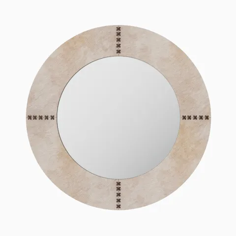 Round mirror wrapped in white hair-on cowhide with organic tonal variation and brown leather whip-stitch accents inspired by saddlework.