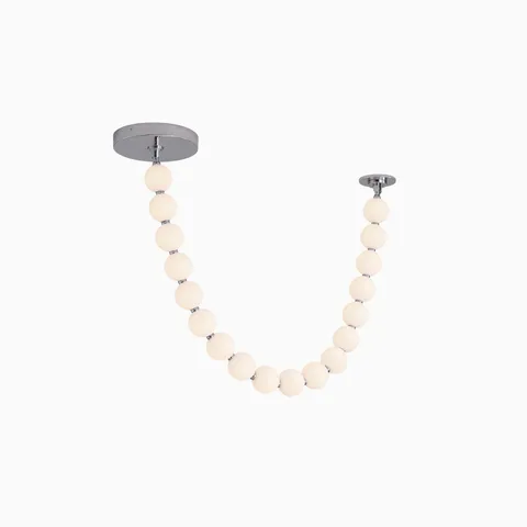 LED pendant with a draped strand of glowing white globes, suspended between two round ceiling mounts for a sculptural effect
