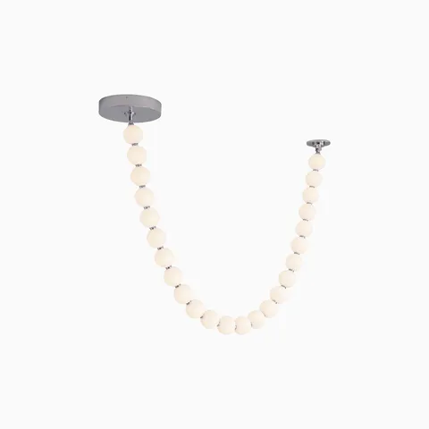 LED pendant with a draped strand of glowing white globes, suspended between two round ceiling mounts for a sculptural effect
