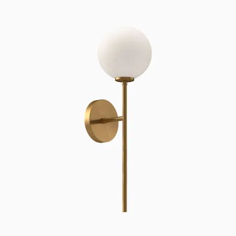 Modern wall sconce with frosted glass globe shade and brushed brass vertical arm and round backplate.