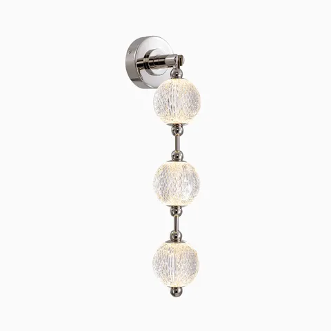 Modern LED vanity light with a chrome wall mount and three textured glass globe shades stacked vertically, creating soft glowing light for contemporary bathroom mirrors.