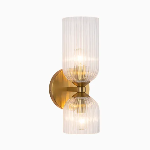 Contemporary vanity wall light with a brushed gold base and two ribbed clear glass shades stacked vertically, offering warm diffused lighting for bathroom spaces.