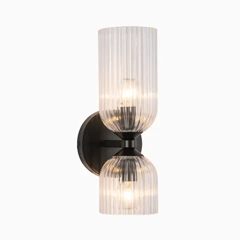 Contemporary vanity wall light with a dark bronze base and two ribbed clear glass shades stacked vertically, offering warm diffused lighting for bathroom spaces.