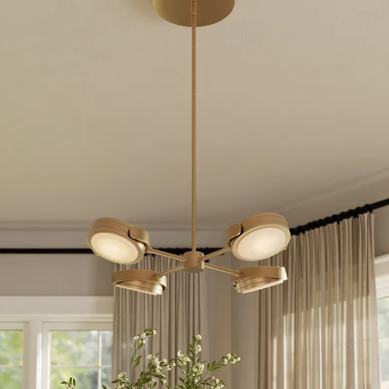 Modern LED pendant light with brushed gold finish and four adjustable round light heads in interior setting.