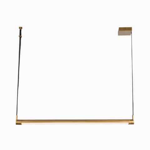 Linear vintage brass pendant light with a cylindrical bar and built-in LED strip, suspended by dark cords to provide modern task lighting above kitchen islands or tables.
