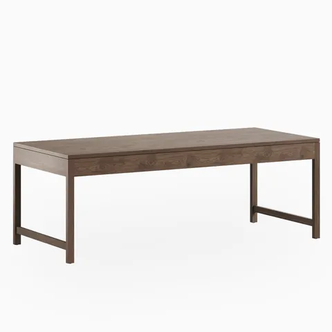 A rectangular walnut dining table with a matte brown finish, shown with a flat, expansive top and minimalist base where slender legs are joined at the ends.